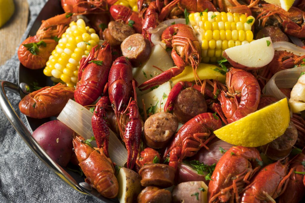 crawfish boil with sausage corn potato's and onions garnished with parsley 