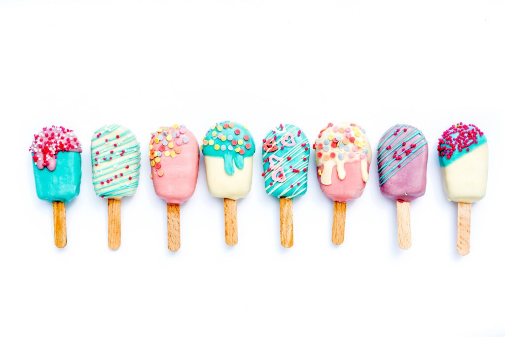 Different variants of cake pops ice creams on white background