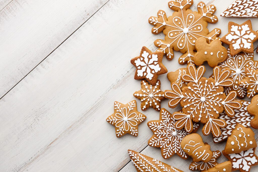 Christmas gingerbread cookies set on white wooden background, top view