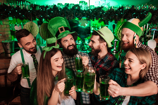 group of friends drinking green beer celebrating st patrick's day with decorations