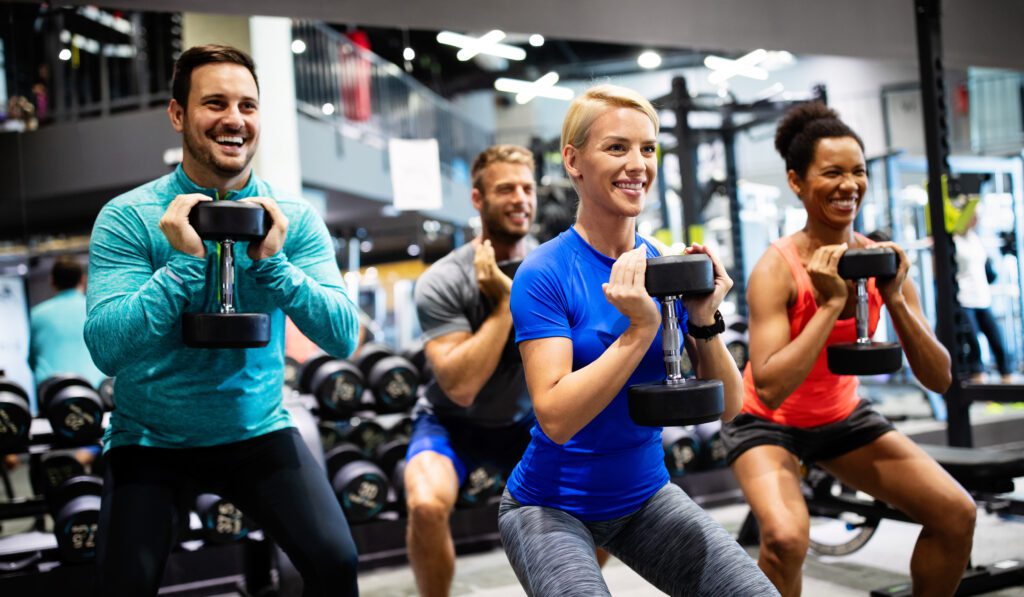 Group of young people fit friends doing exercises in gym